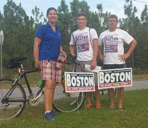 Carol Boston with supporters holding bikes and campaign signs
