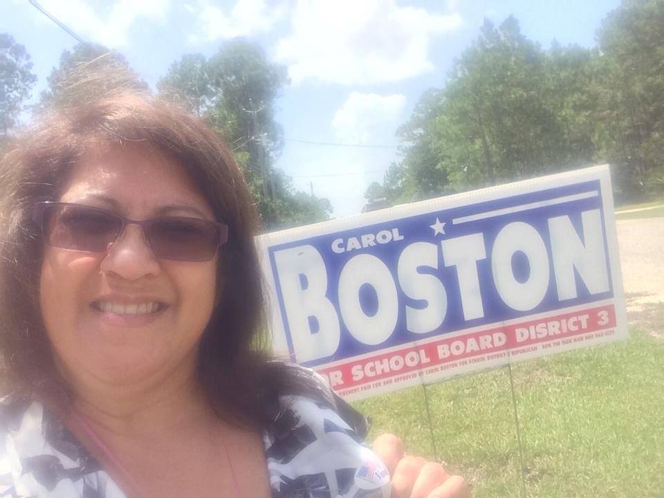 Supporter taking a selfie with a Carol Boston yard sign
